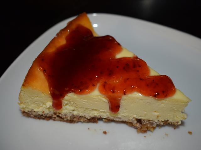 image of a slice of cheesecake topped with strawberry jam