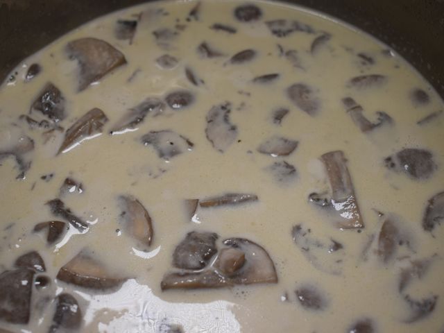 image of heating the cream with the cooked mushrooms