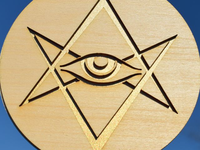 wood disk with symbol cut through, mounted on gold vellum