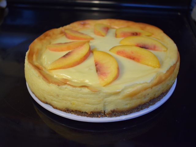 image of almond amaretto cheesecake with fresh peach slices