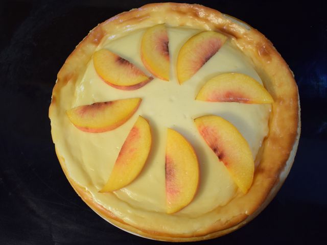 image of finished cheesecake topped with peach slices