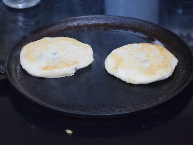 image of pupusas cooking on cast iron skillet